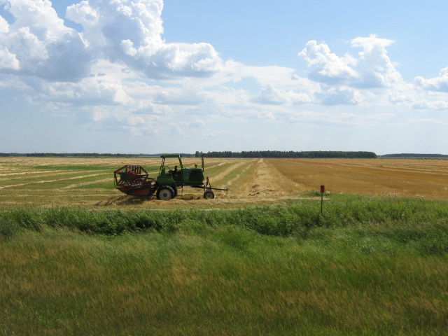A long shot of a tractor in a vast field of land.